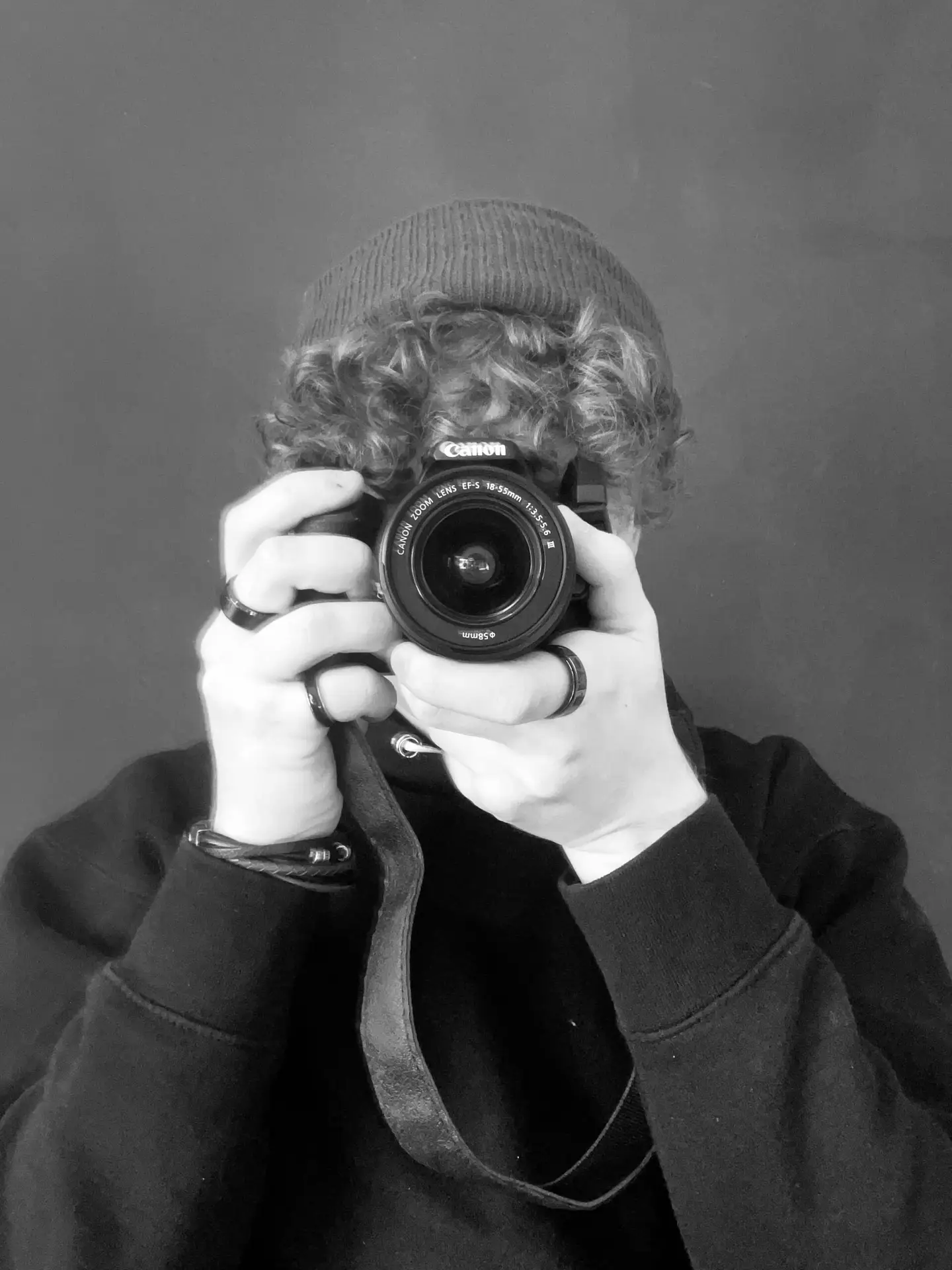 Portrait of a photographer holding up a camera to their face.